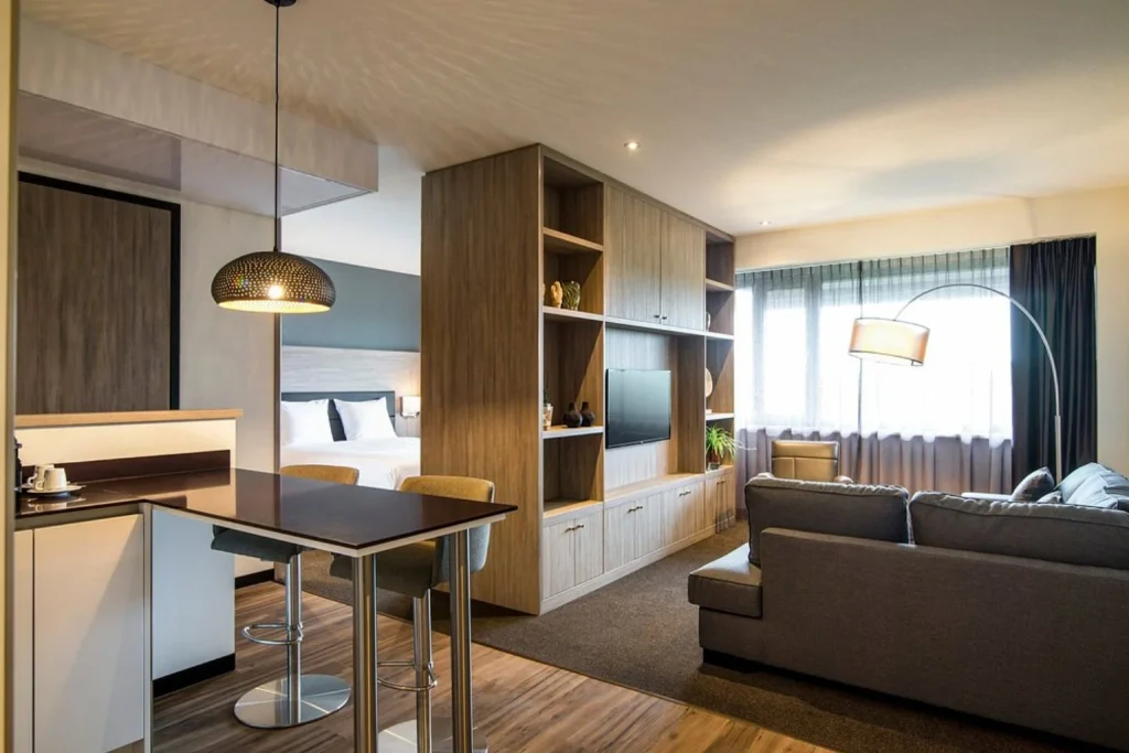 Spacious apartment at Adagio Amsterdam City South featuring a kitchen, dining area, separate bedroom and comfortable living space