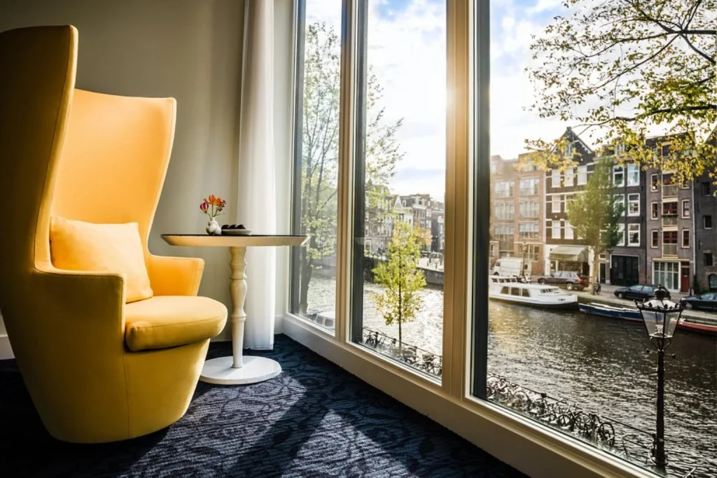 Sunlit interior with panoramic windows overlooking the picturesque Prinsengracht canal at Andaz Amsterdam Prinsengracht.
