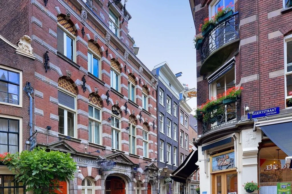 Historic red-brick facade surrounded by traditional architecture on a narrow city street at Best Western Dam Square Inn Amsterdam.