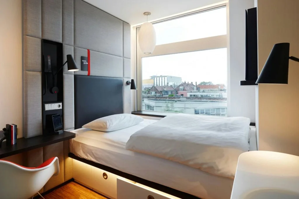 Modern room with large window and city view at citizenM Amsterdam City