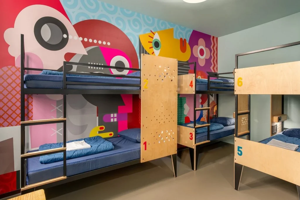 Colorful hostel dorm room with bunk beds and vibrant wall art at Stayokay Amsterdam Stadsdoelen, Amsterdam