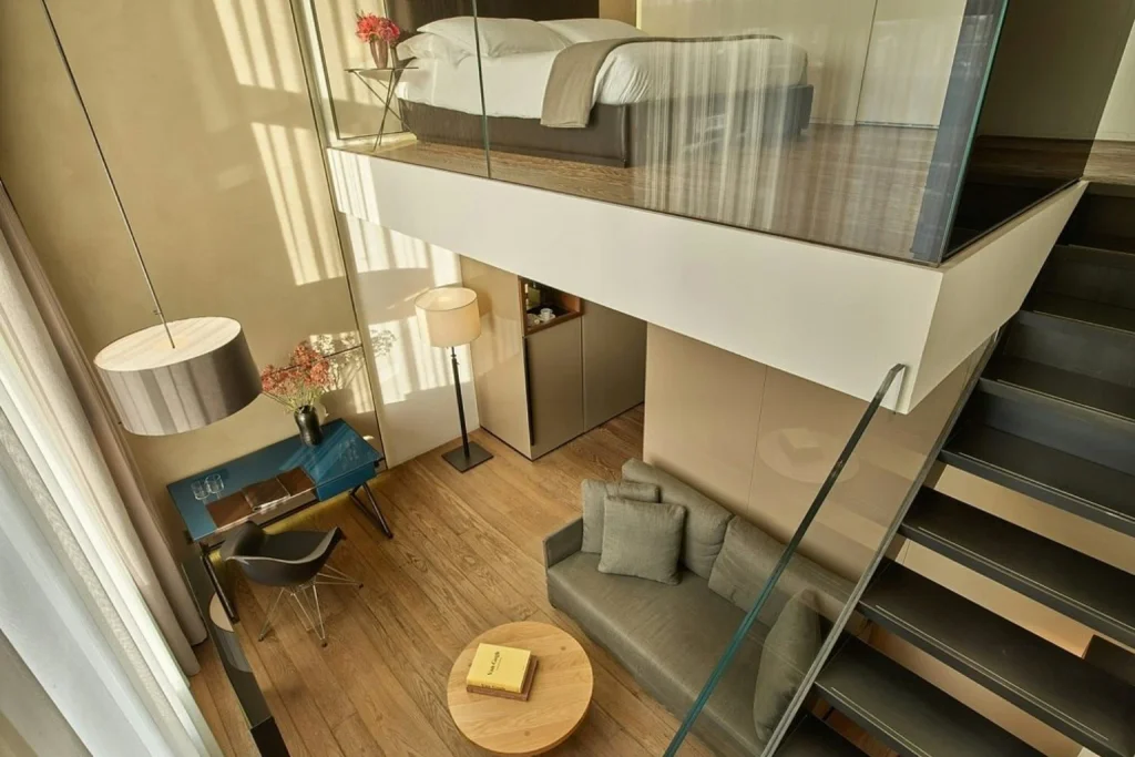 Luxury duplex suite with elevated bedroom, glass walls and contemporary living area at Conservatorium Hotel, Amsterdam