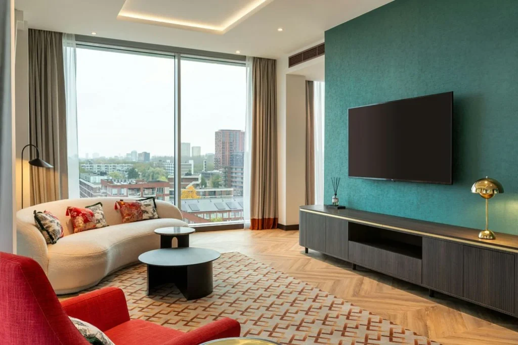 Stylish living area with panoramic windows, contemporary furnishings and city views at Corendon Amsterdam New-West.