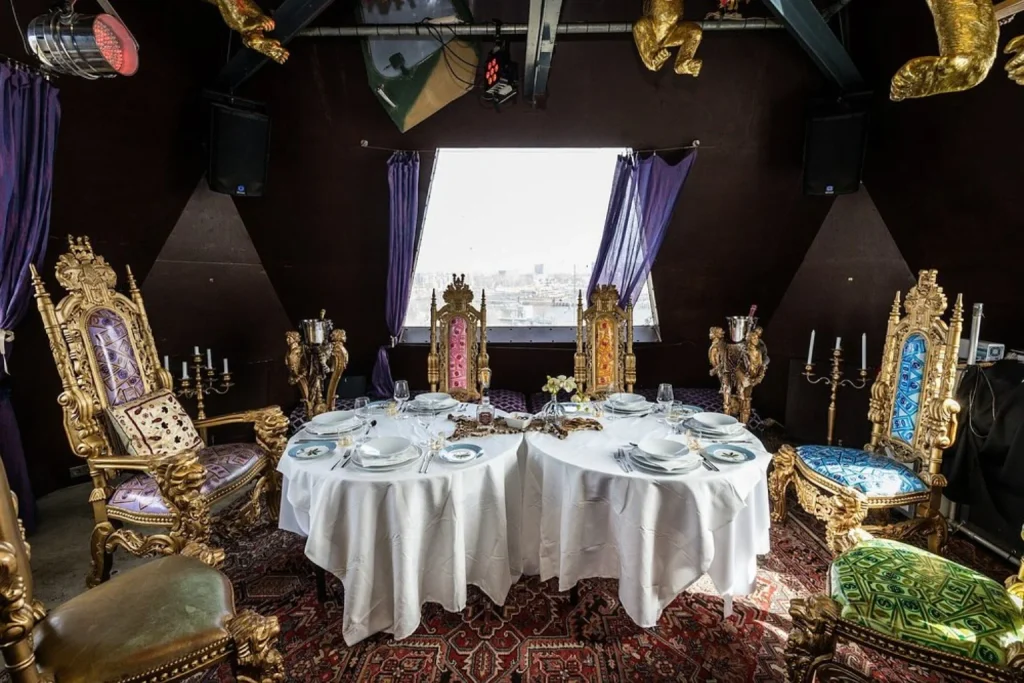 Dramatic private dining setting with ornate gold chairs, elegant tableware and panoramic views at Crane Hotel Faralda Amsterdam.
