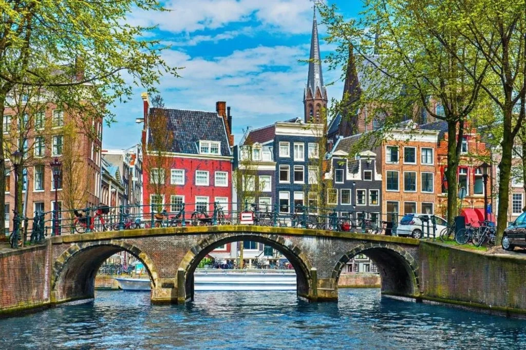 Scenic canal, historic bridge and traditional Dutch architecture in the city centre near Crown Hotel Amsterdam.