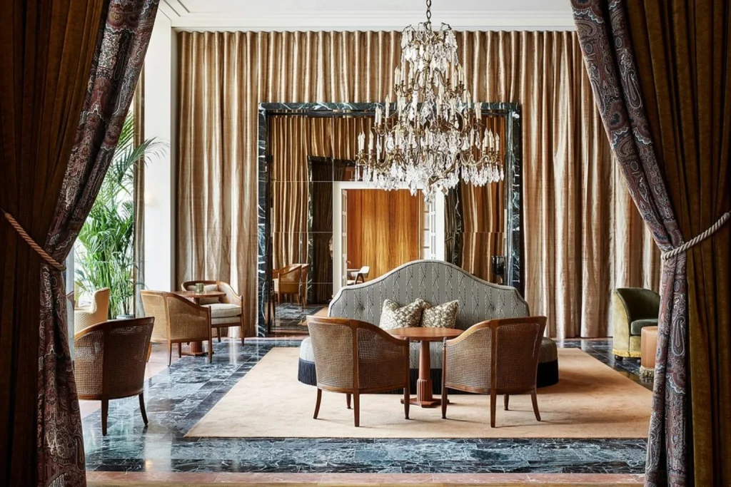 Elegant luxury lounge with crystal chandelier, marble floor and classic seating at De L’Europe Amsterdam