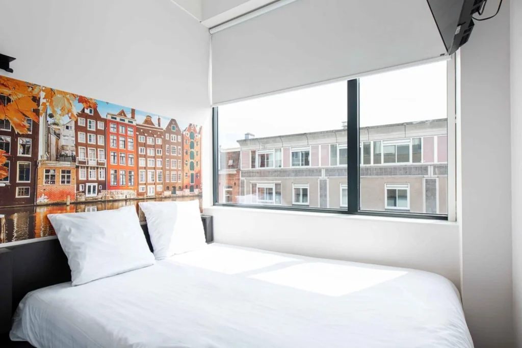 Bright double room with a large window and city view at easyHotel Amsterdam City Centre South.