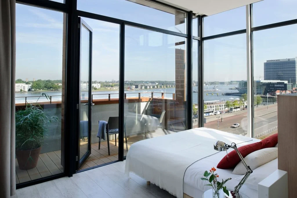 Bedroom with balcony and waterfront views at Eric Vökel Amsterdam Suites