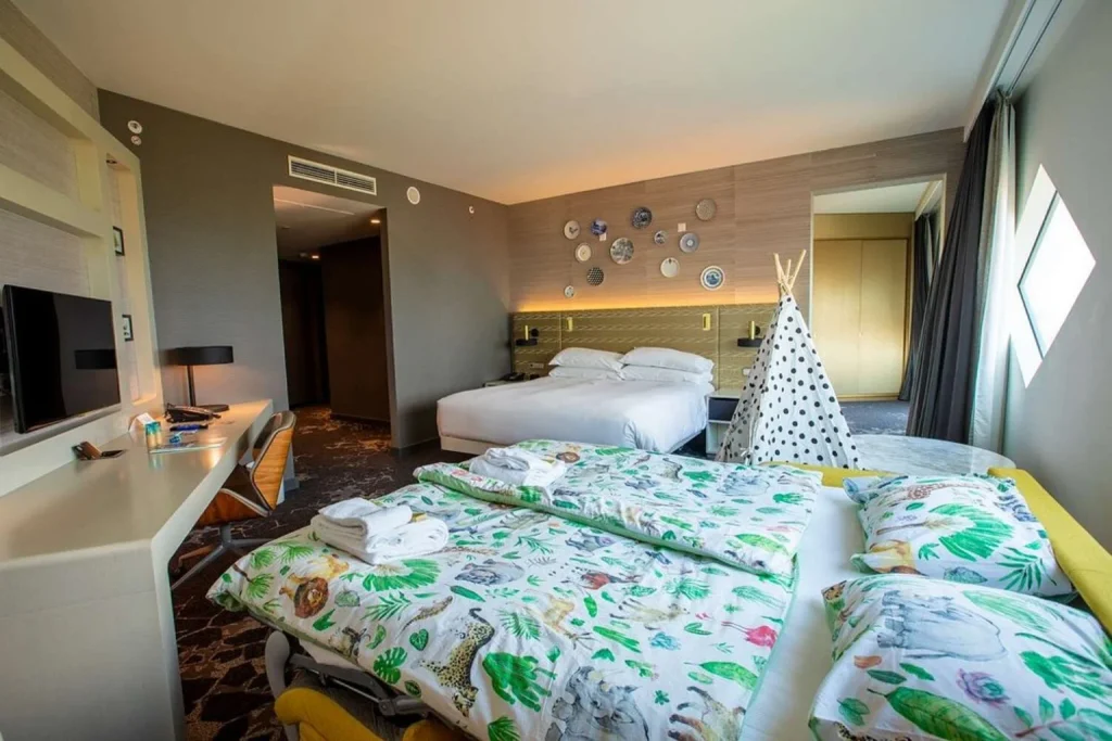 Spacious family room at Hilton Amsterdam Airport Schiphol with a double bed, children’s sleeping area and playful indoor tent.