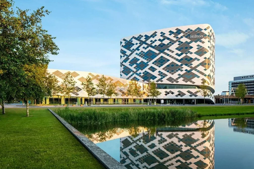 Hilton Amsterdam Airport Schiphol hotel with distinctive geometric facade reflected in a pond