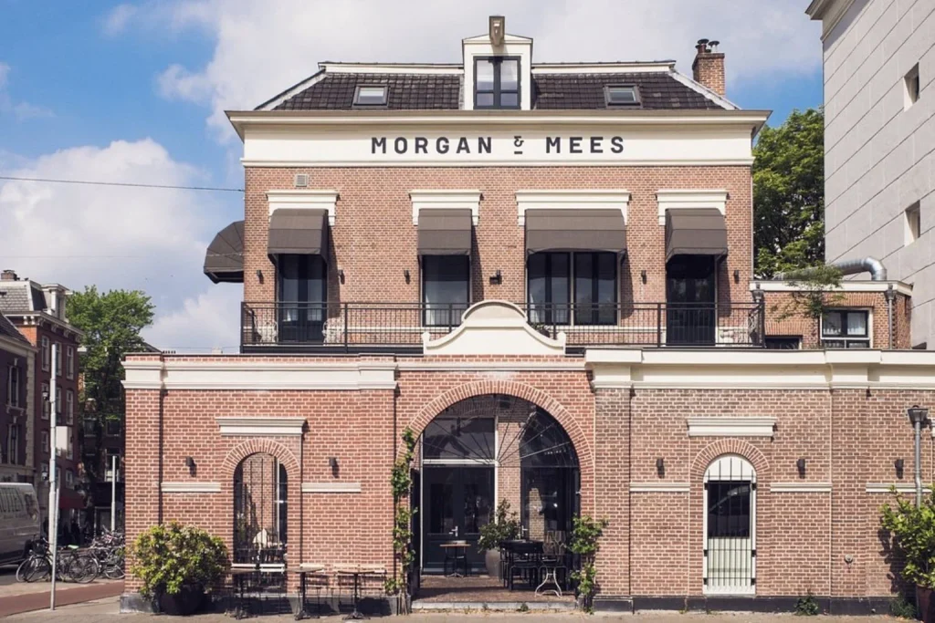 Historic brick hotel exterior with large arched entrance at Morgan & Mees, Amsterdam