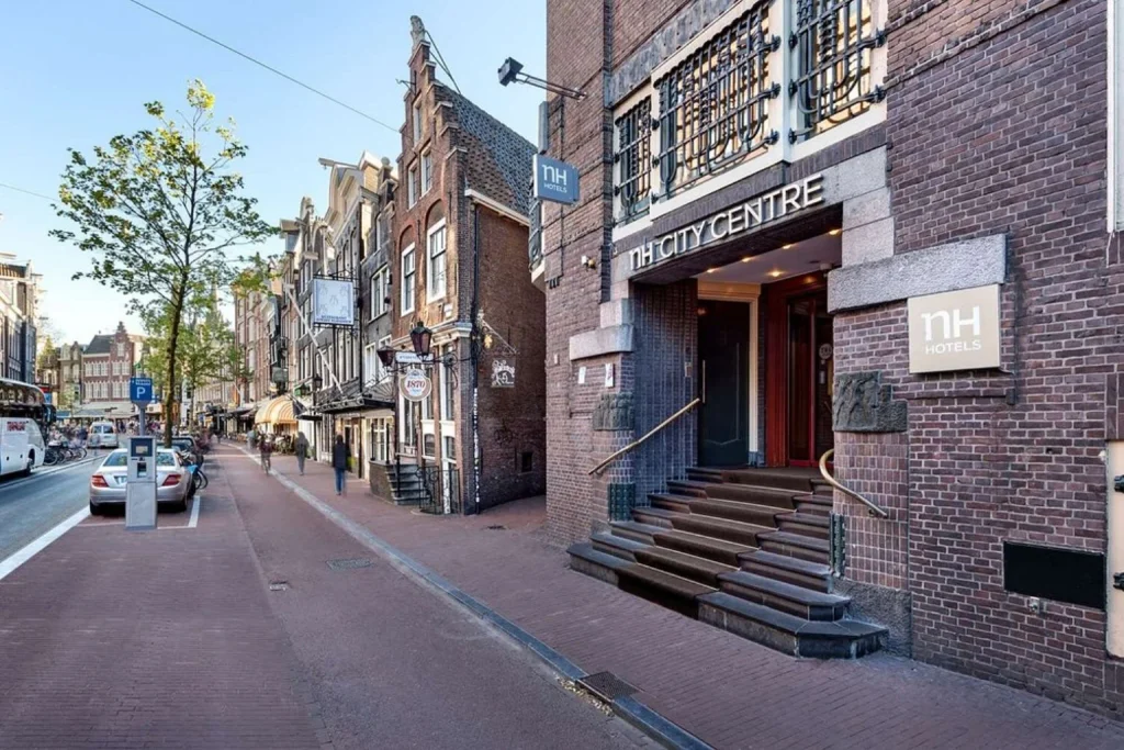 Historic brick hotel entrance on a lively central Amsterdam street at NH City Centre Amsterdam, Amsterdam