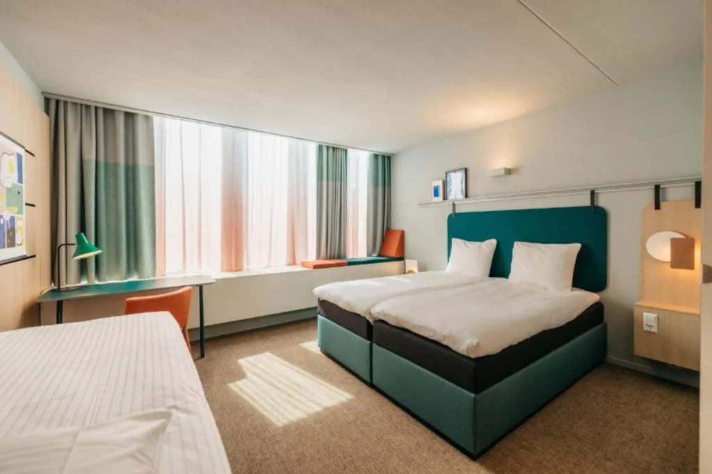 Bright modern twin room with large windows and workspace at Hotel Casa Amsterdam