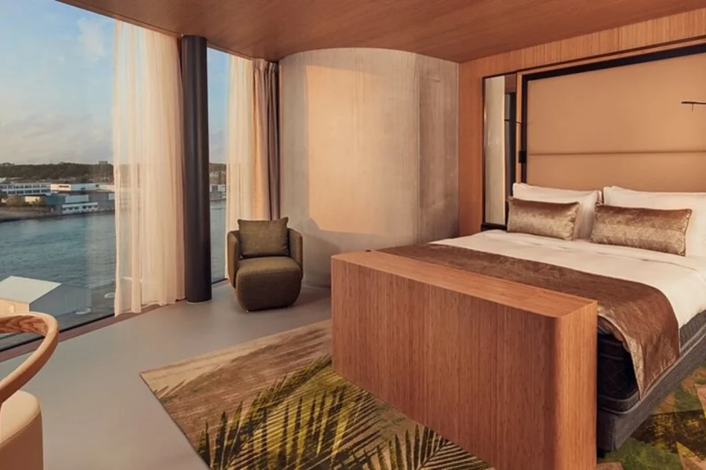 Modern hotel room with a king bed and panoramic water views at Hotel Jakarta Amsterdam