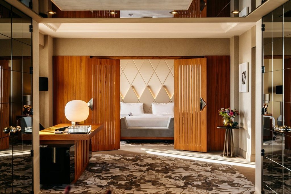 Luxury suite with wooden sliding doors, spacious living area and elegant bedroom at Hotel Okura Amsterdam
