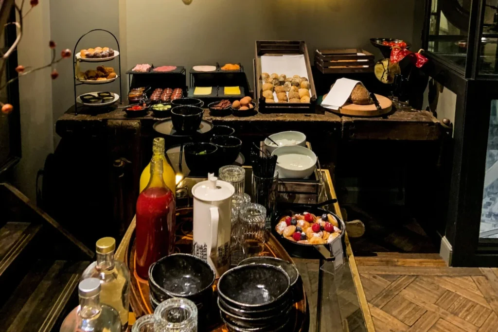 Atmospheric breakfast buffet with artisan bread, pastries, cheese, fruit and morning drinks at Hotel The Craftsmen, Amsterdam.