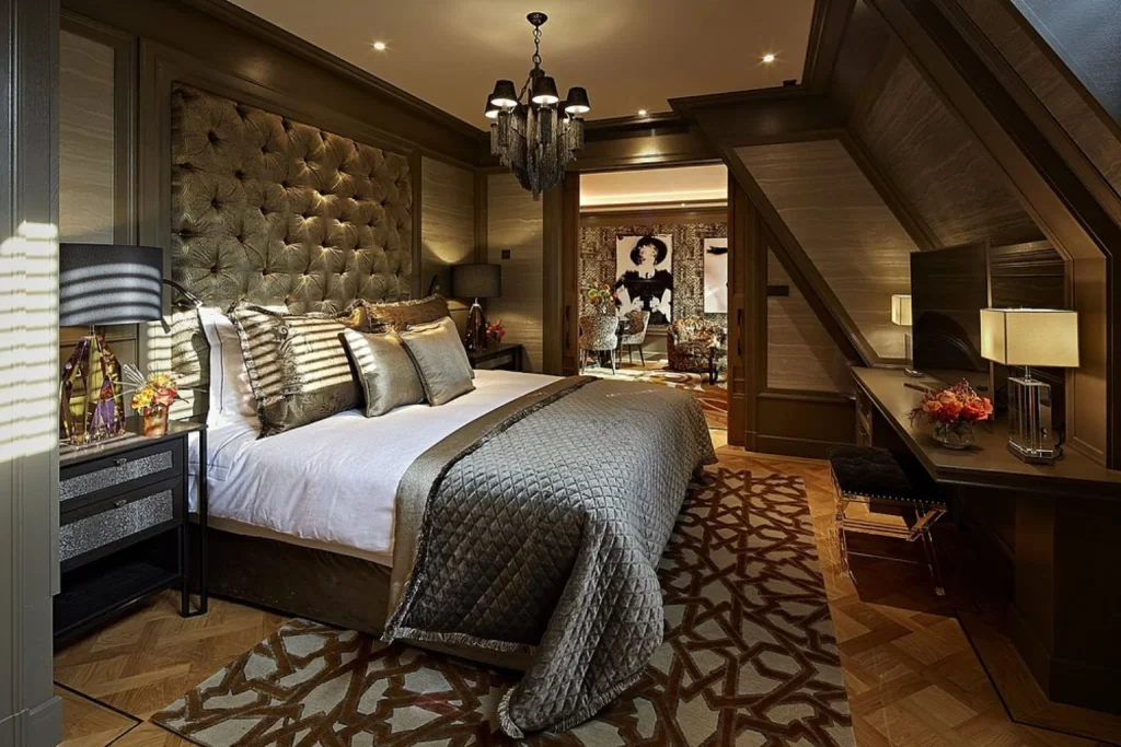 Opulent luxury bedroom featuring a tufted headboard, statement chandelier, rich wood panelling and sophisticated furnishings at Hotel Twenty Seven, Amsterdam.