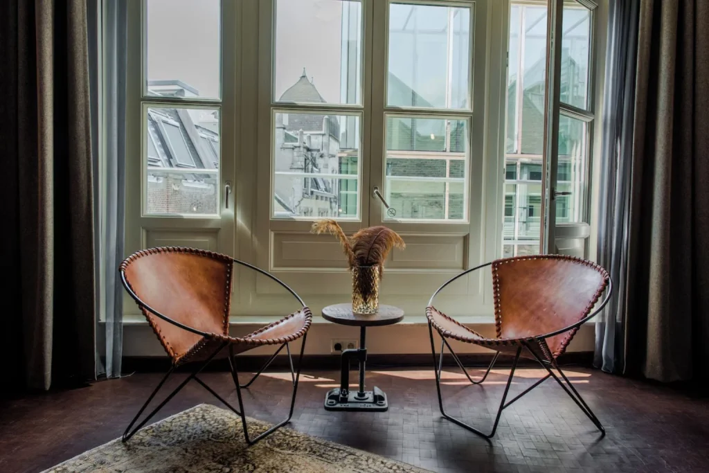 Hotel room balcony with leather chairs and views over central Amsterdam at Hotel V Nesplein