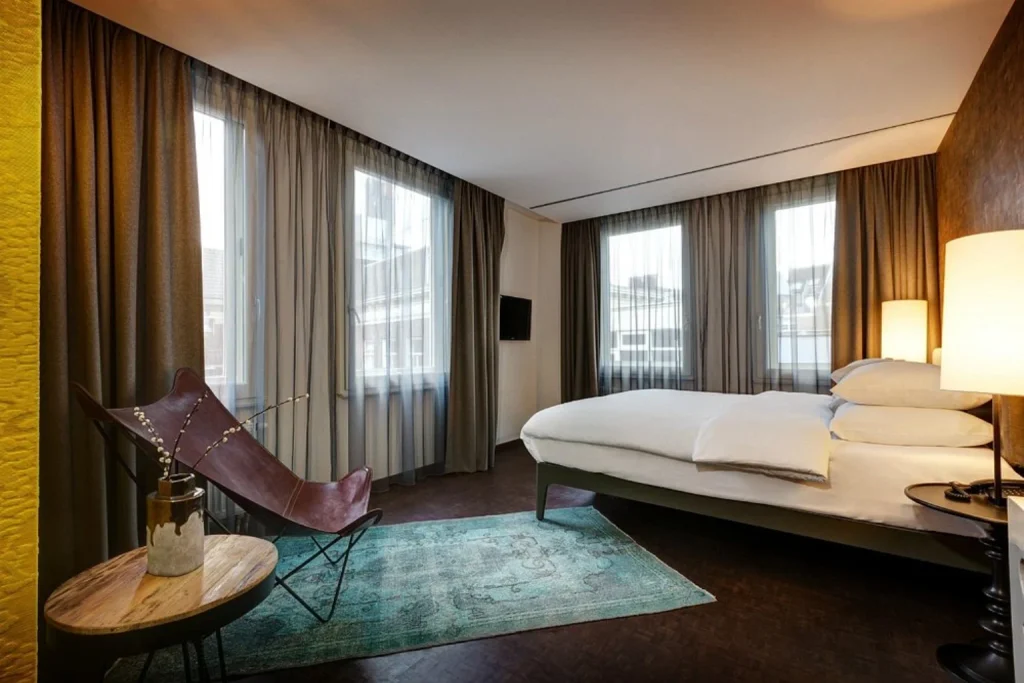 Spacious double room with large windows and modern furnishings at Hotel V Nesplein in Amsterdam