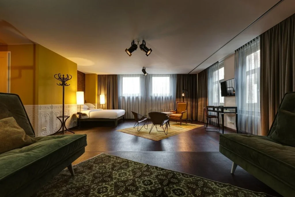 Spacious suite with bedroom and lounge area at Hotel V Nesplein Amsterdam
