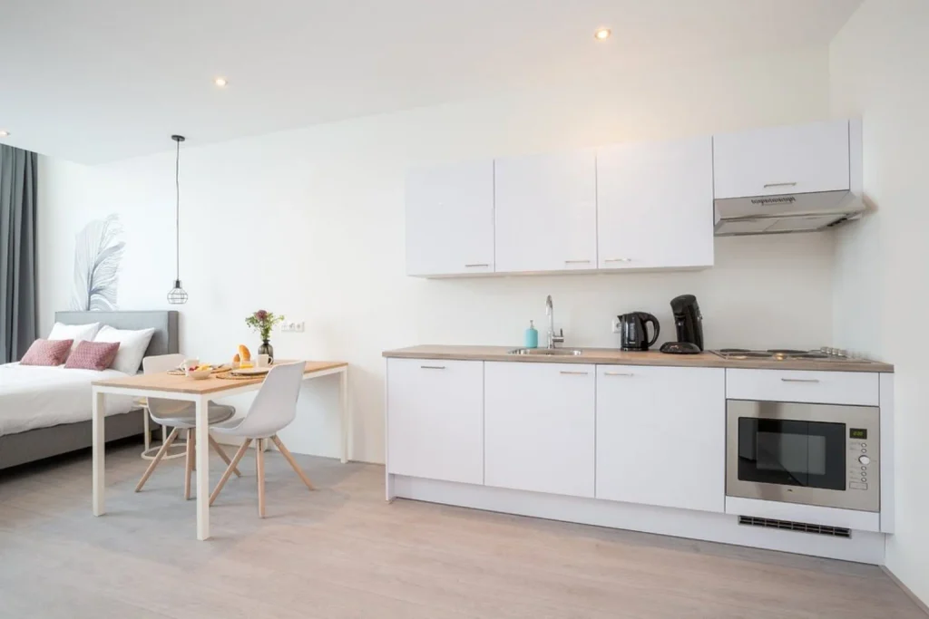 Bright studio apartment with a fully equipped kitchenette, dining space and comfortable sleeping area at Hotel2Stay, Amsterdam.