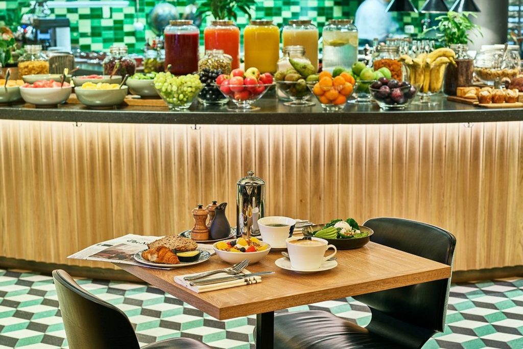 Breakfast buffet with fresh fruit, pastries and a set dining table at Hyatt Regency Amsterdam