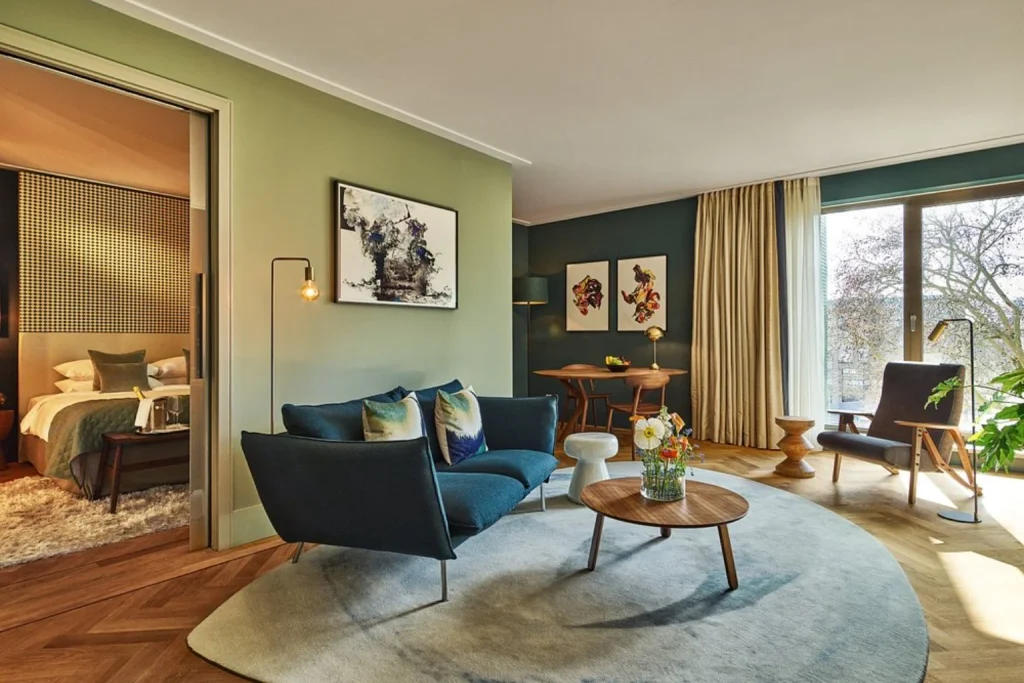 Spacious luxury suite with separate bedroom, blue sofa and contemporary living area at Hyatt Regency Amsterdam