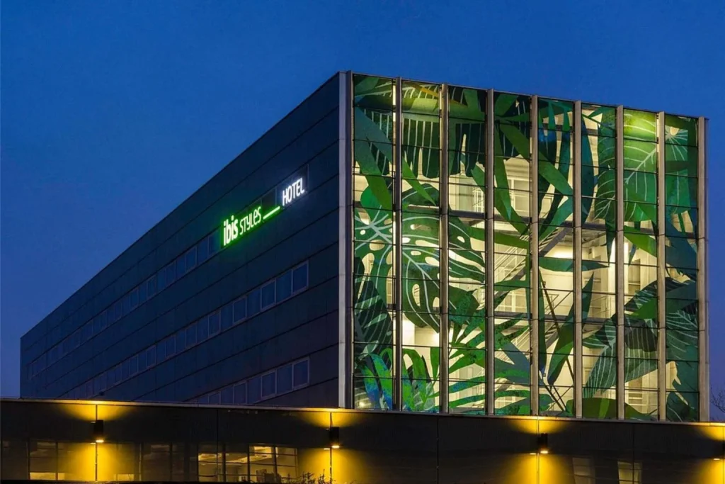 Modern hotel exterior of ibis Styles Amsterdam Airport at night