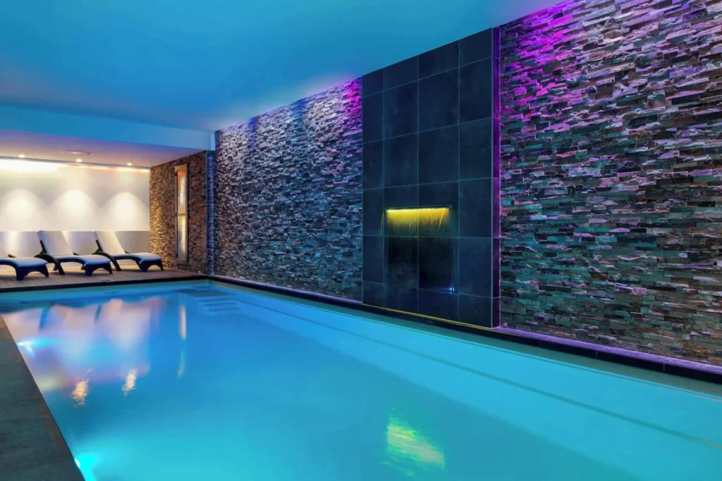 Atmospheric indoor swimming pool with colourful lighting and stone walls, Corendon Amsterdam New-West