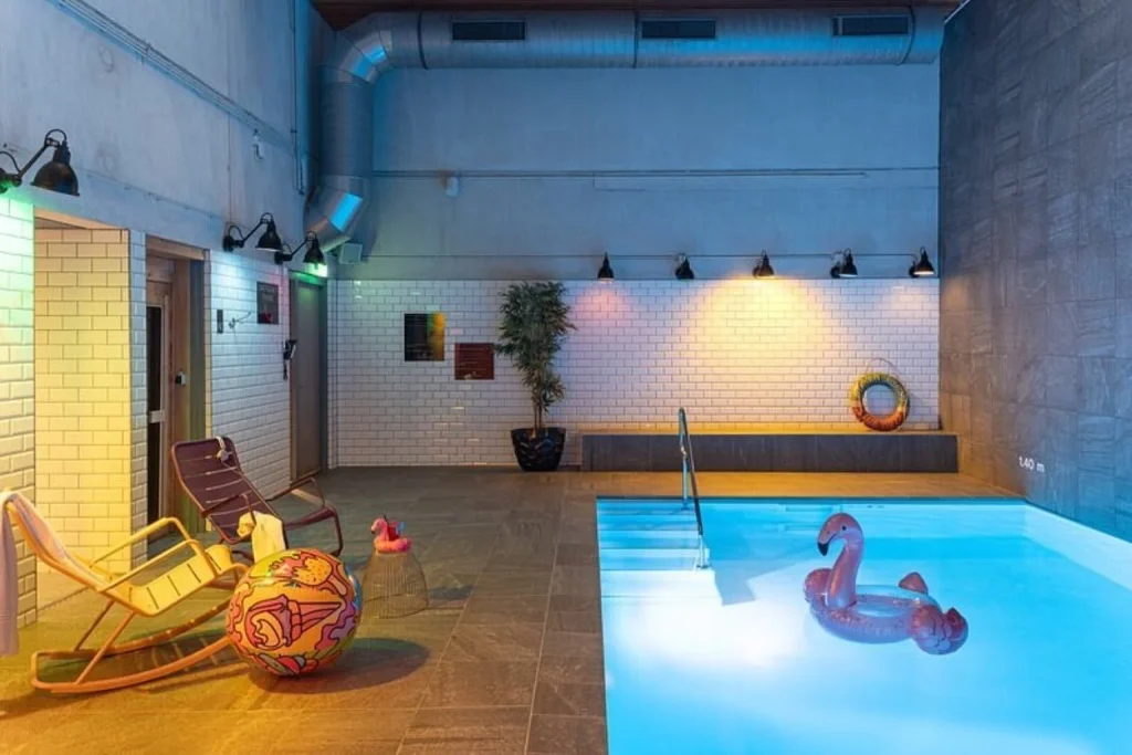 Playful indoor swimming pool with colourful lighting and quirky decor, Moxy Amsterdam Houthavens
