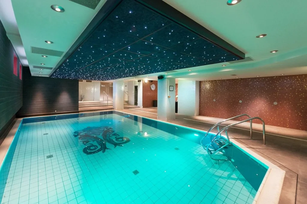 Indoor swimming pool with star-lit ceiling and modern spa interior at Grand Hotel Amrâth, Amsterdam