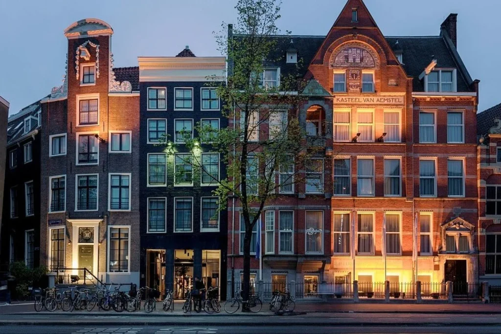 Illuminated historic hotel façade and traditional canal houses in the city centre, INK Hotel Amsterdam, Amsterdam