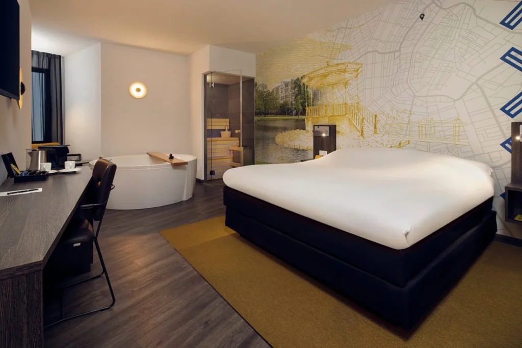 Wellness room with private sauna, whirlpool bathtub and king bed at Inntel Hotels Amsterdam Centre
