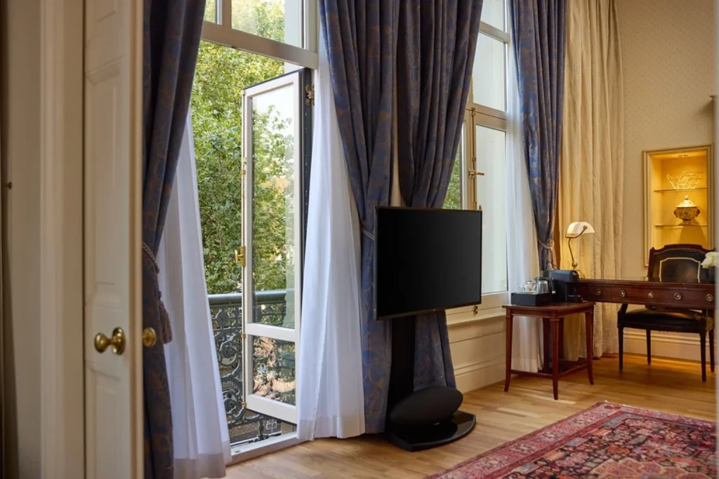 Elegant guest room with French balcony and tall windows at InterContinental Amstel Amsterdam