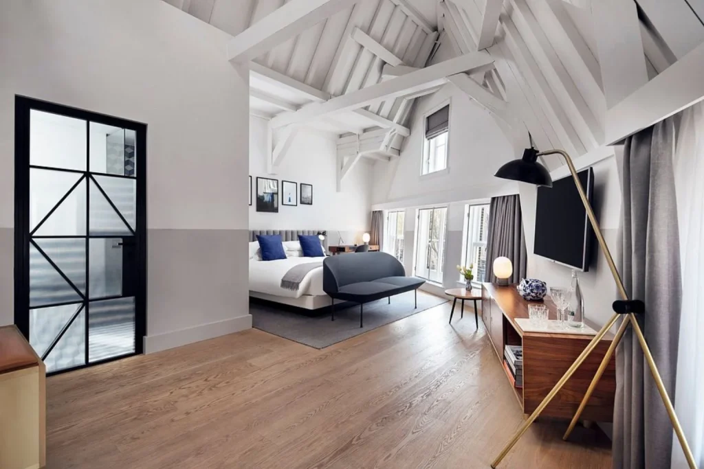 Modern loft suite bedroom with exposed beams at Kimpton De Witt Amsterdam in Amsterdam, Netherlands