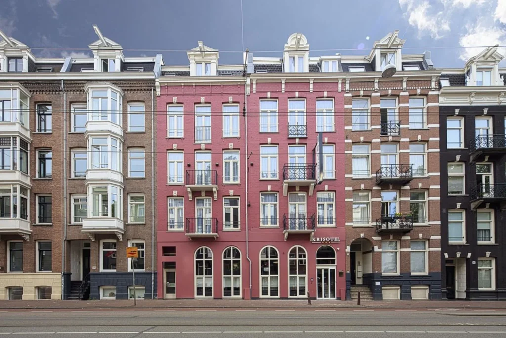 Historic hotel exterior with a distinctive red facade at Krisotel Amsterdam.