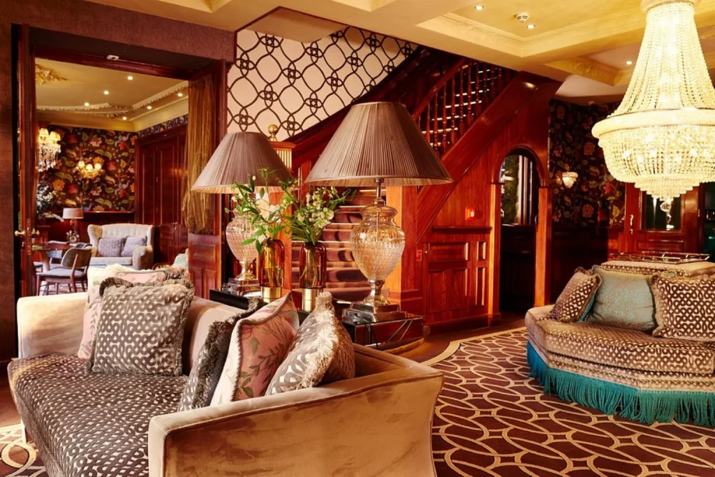 Luxurious lounge with crystal chandelier, elegant seating and rich wood interiors at Hotel Estherea, Amsterdam