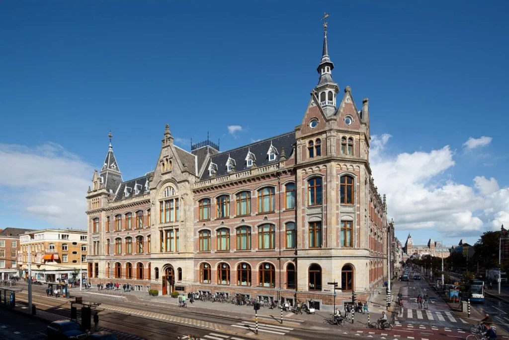 Grand historic building with ornate towers and arched windows, Mandarin Oriental Conservatorium, Amsterdam