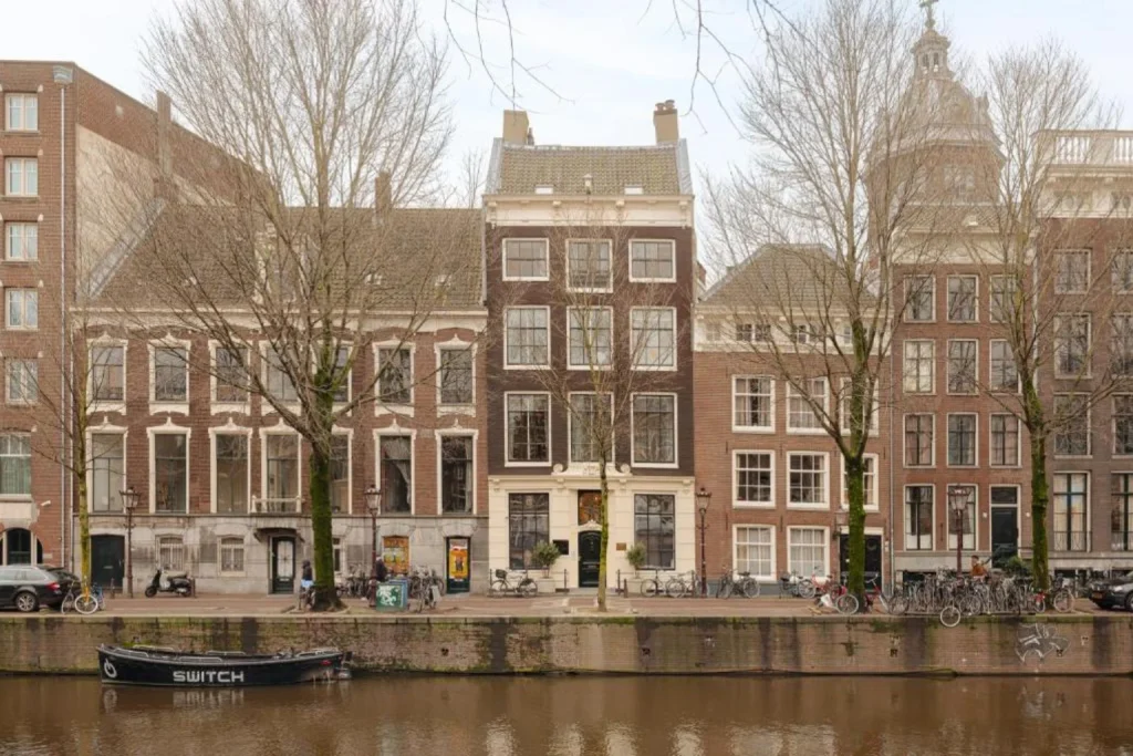 Traditional canal houses and a peaceful waterfront scene in central Amsterdam at Mauro Mansion Amsterdam.