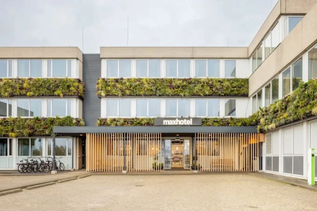 Modern hotel entrance with vertical gardens and bicycle parking at Maxhotel Amsterdam Airport Schiphol, Hoofddorp, Netherlands