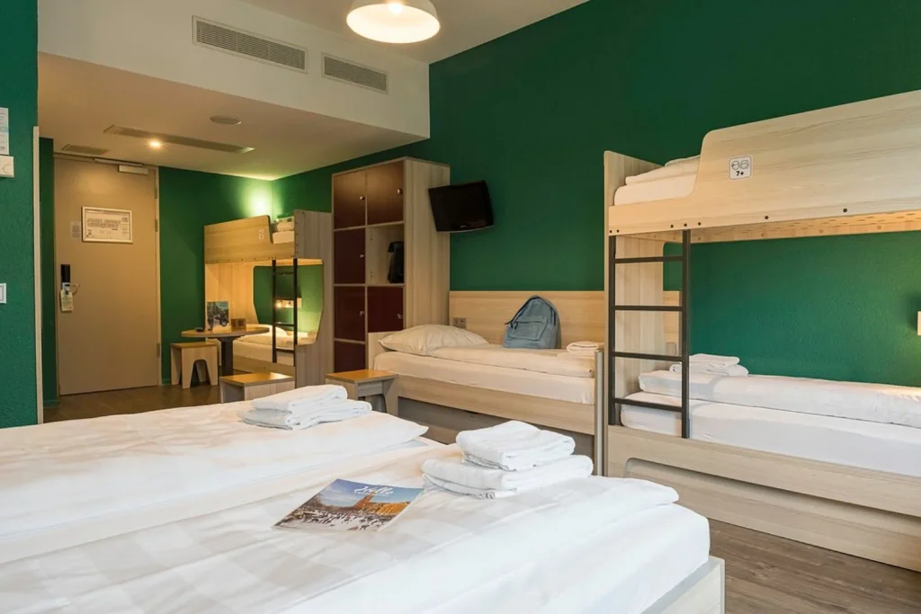 Spacious family room with multiple beds and bunk beds at MEININGER Hotel Amsterdam City West.