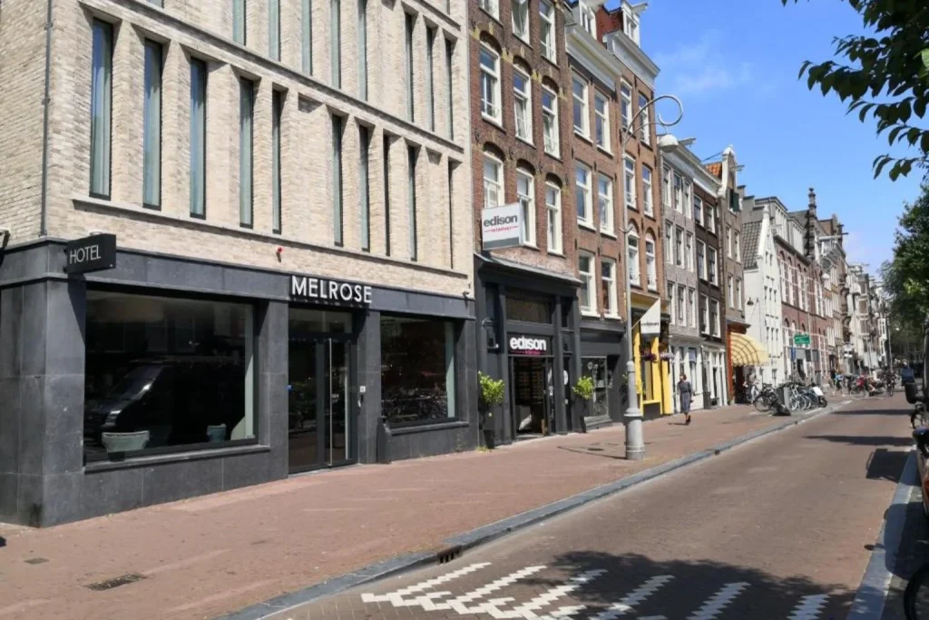 Modern hotel exterior along a city street at Melrose Hotel in Amsterdam.