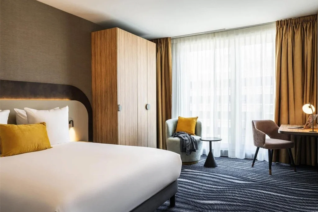 Modern hotel bedroom with double bed, seating area and work desk at Mercure Amsterdam North Station