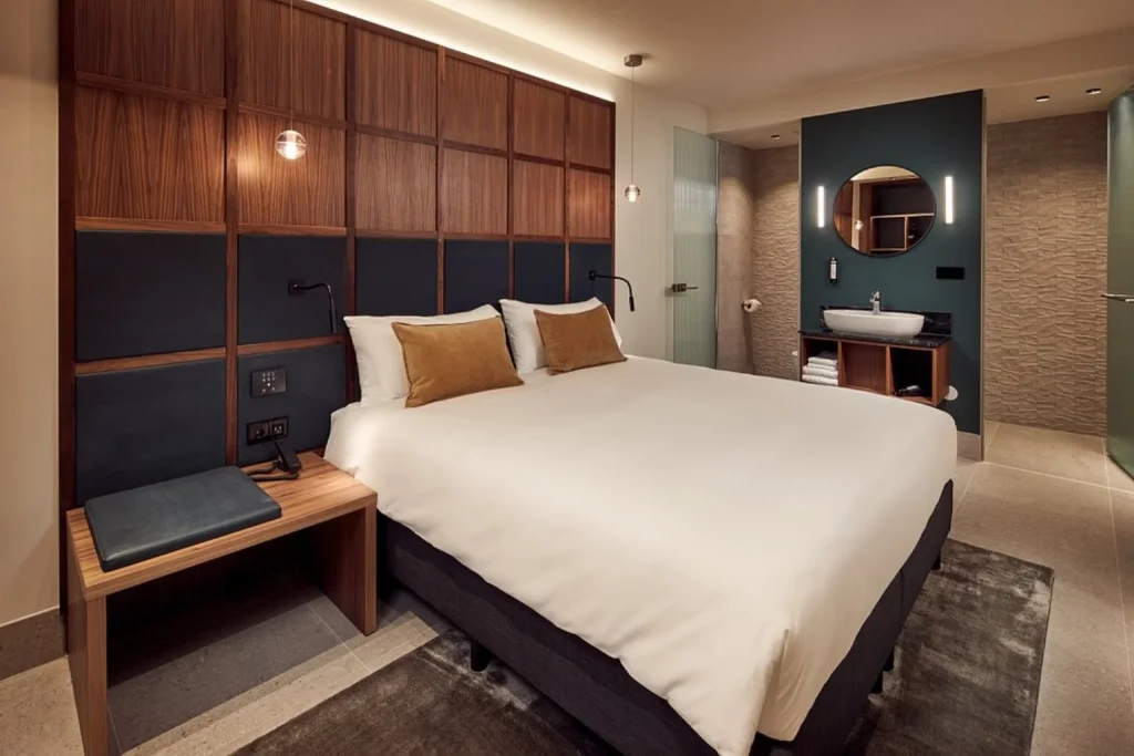 King room with modern wooden furnishings and open bathroom at Met Hotel Amsterdam