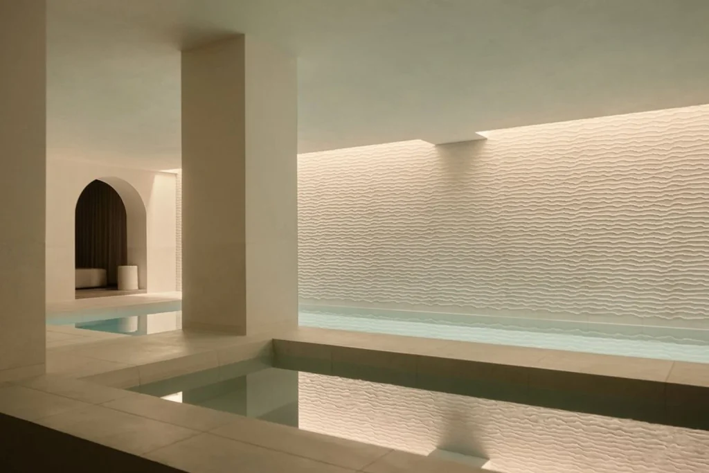 Minimalist indoor spa pool with soft lighting and textured walls at Rosewood Amsterdam, Amsterdam