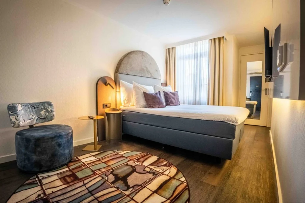 Contemporary guest room with a double bed, stylish seating and modern décor at The Albus Hotel Amsterdam City Centre, Amsterdam.