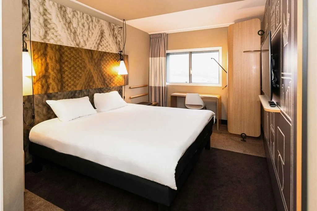 Modern double guest room with work desk, large window and contemporary interior at Ibis Amsterdam Centre, Amsterdam