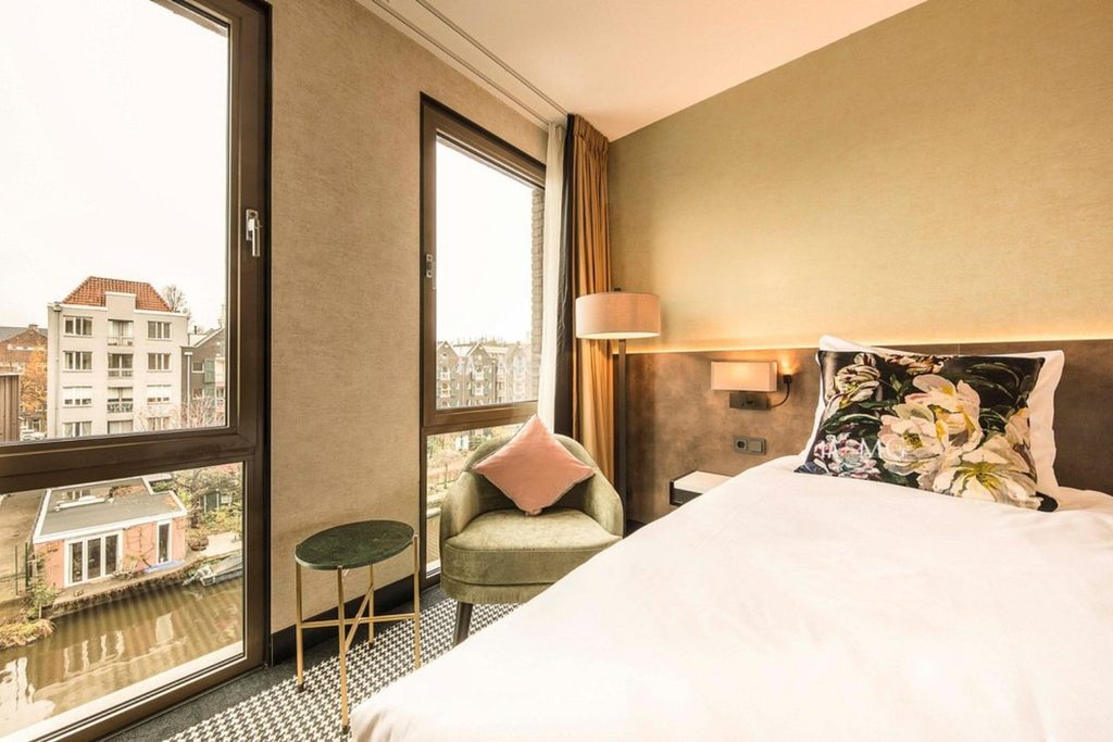 Modern hotel room with large windows and canal view at Monet Garden Hotel Amsterdam, Amsterdam