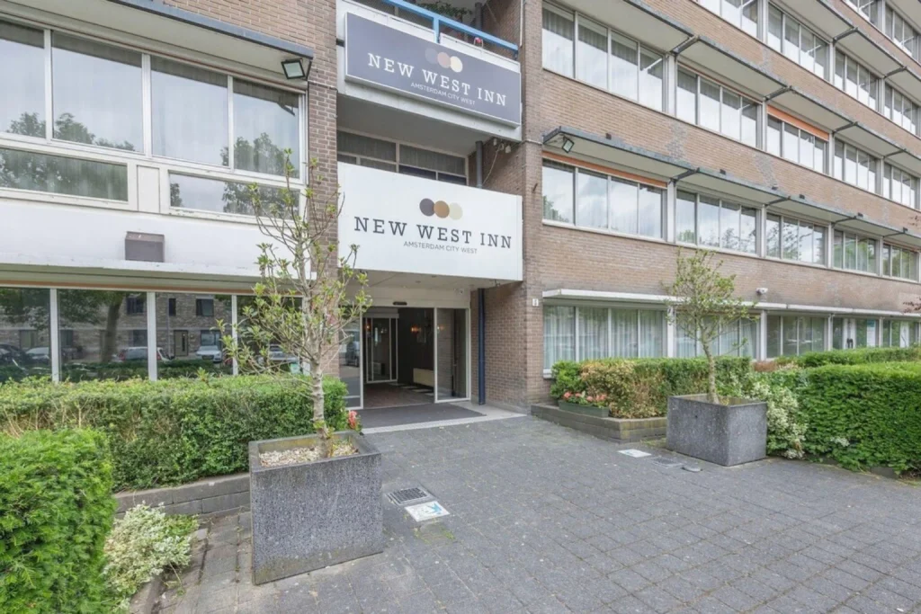 Exterior of the hotel building with landscaped greenery and main entrance, New West Inn Amsterdam, Amsterdam