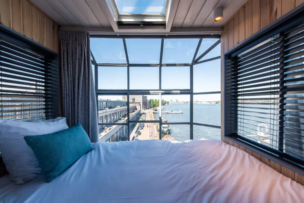 Bedroom with panoramic waterfront views at Numa Amsterdam The Crane